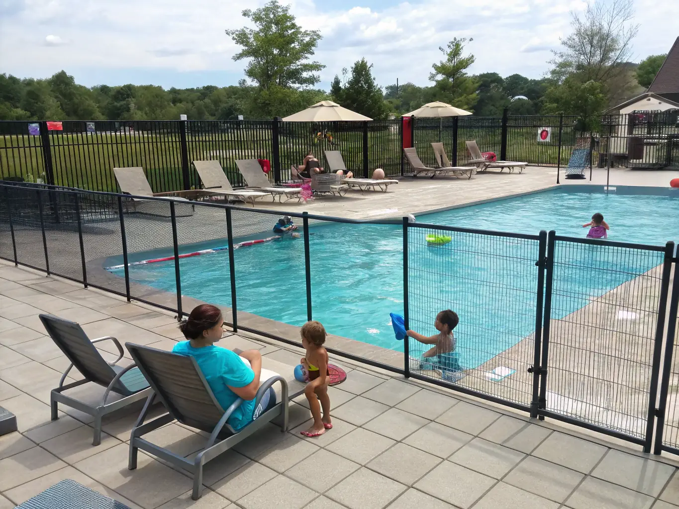 A vibrant image showcasing the heated swimming pool and spa area at Southport Tourist Park, with families enjoying the water and relaxation facilities under the sun.